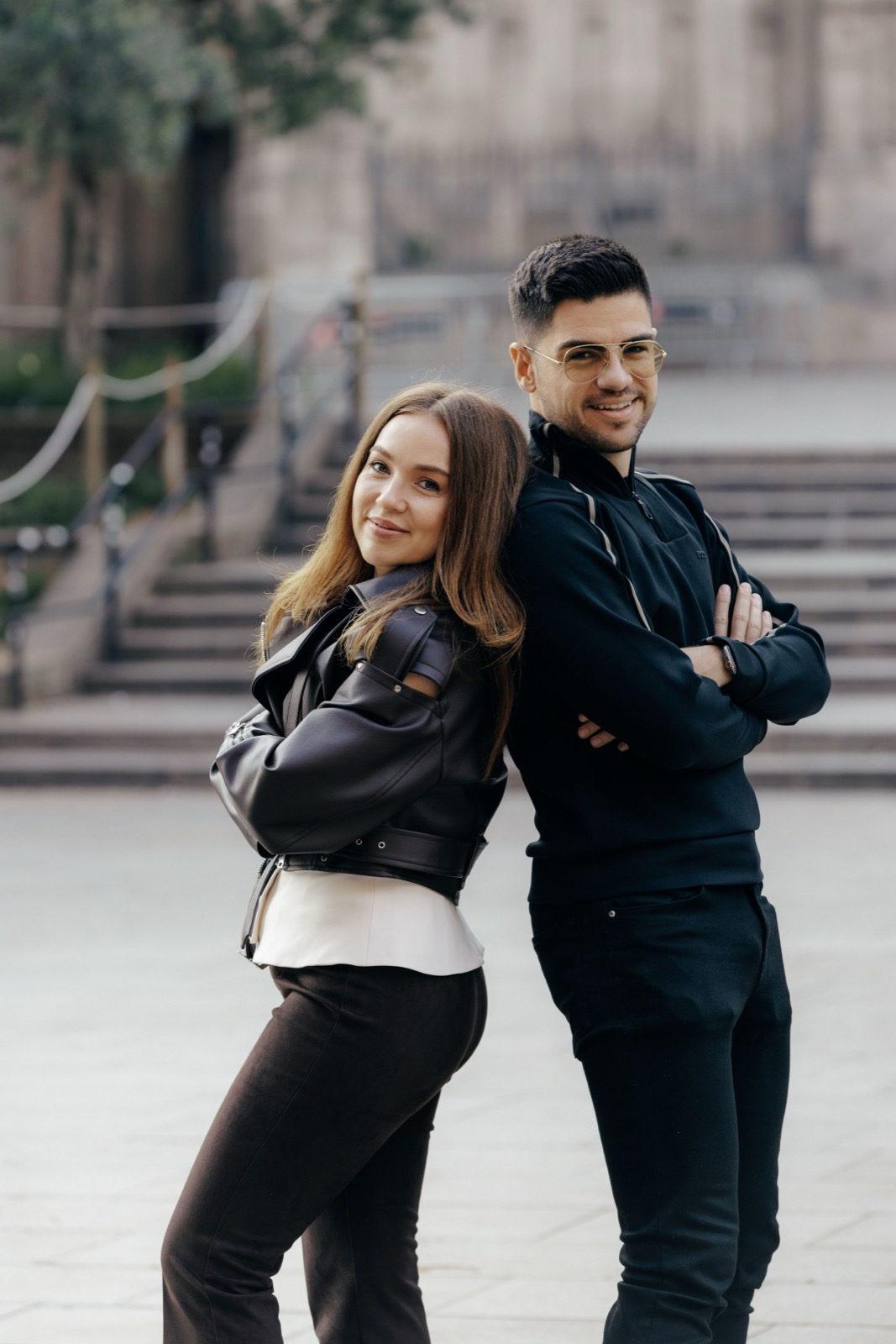 Olga and Daniel, the two founders of Jed, standing back to back on a street in Barcelona